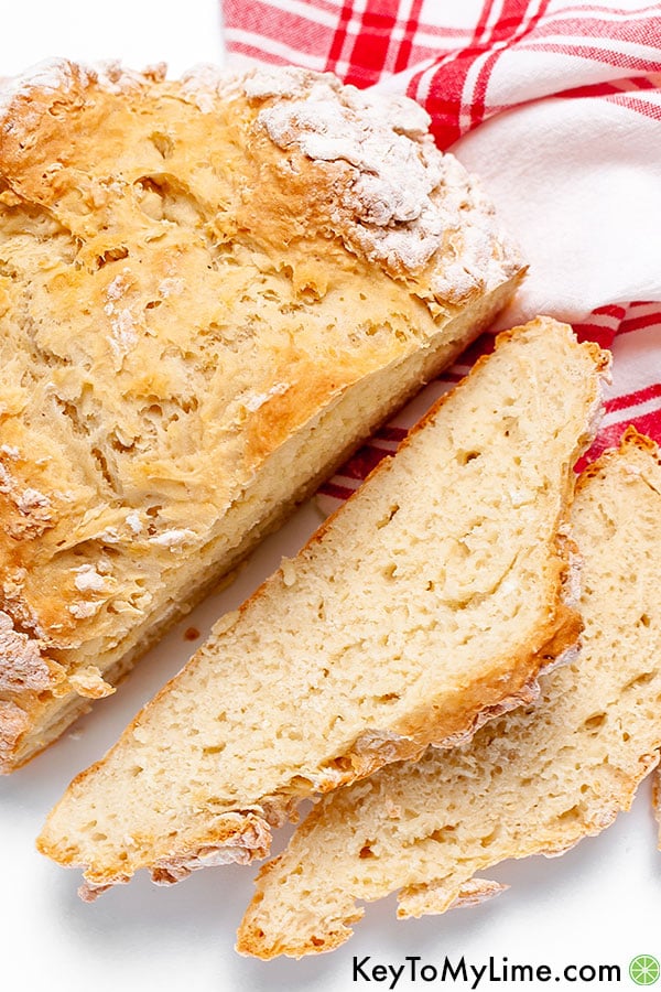 A sliced soda bread loaf against a red and white napkin.