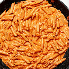 Tomato basil cream sauce pasta in a skillet.