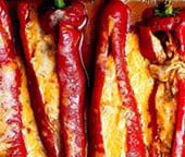 Rotisserie chicken enchilada stuffed peppers in a baking tray.