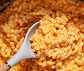 Scooping a serving of the best slow cooker mac and cheese.